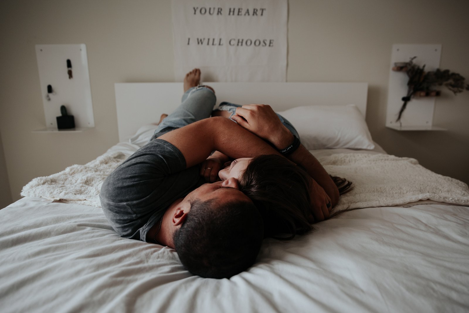 Мужчина без эректильной дисфункции и проблем с потенцией лежит в постели рядом с женщиной, оба обнимаются.